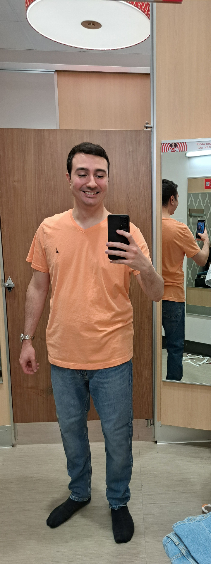 Sam smiling in an orange tee