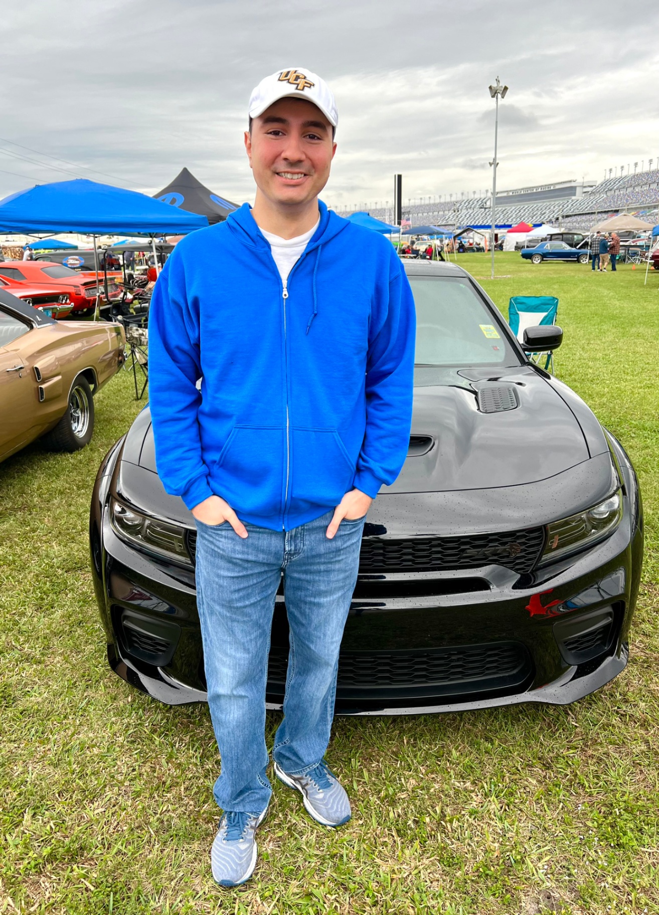 Sam at a car show in a blue hoodie